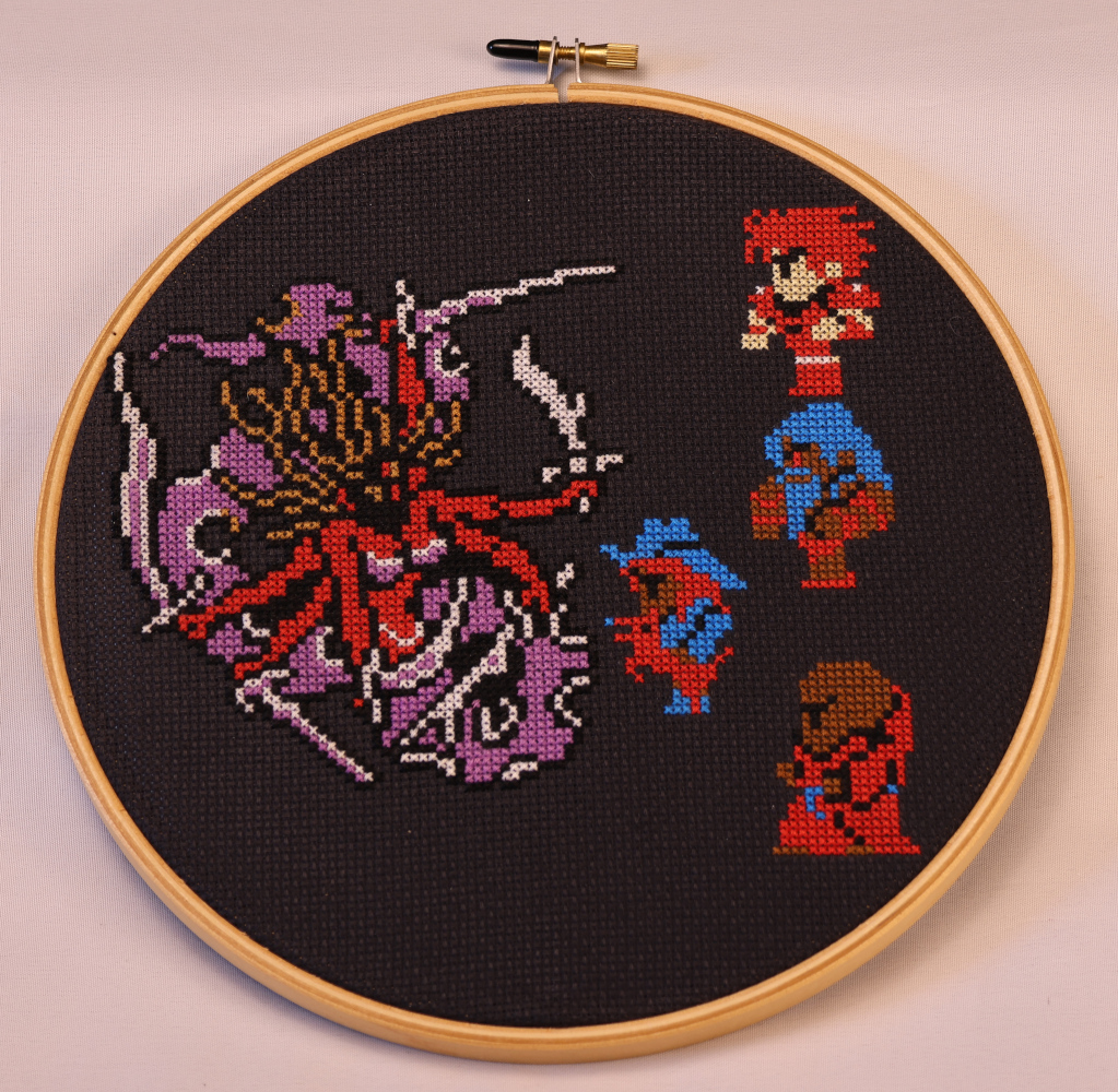 Photograph of a cross stitch on black aida. Kary the Fiend of Fire is depicted on the left: a red-skinned woman with a purple snake's tail. Her hair waves wildly aboud her, and she has six arms, each holding a different sword. Opposing her is a line of FF1 adventurer sprites: the fighter at the top, then my barbarian, my beast master, and my psion. The Beast Master has stepped forward to attack. Their arm is down now, but the dog has reared up and its mouth is open to bite Kary.
